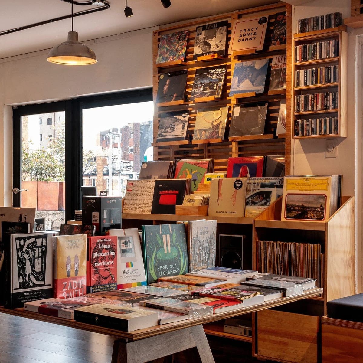 La sede de Chapinero: la pared de vinilos sobre la mesa de novedades, con la ventana a la calle al fondo